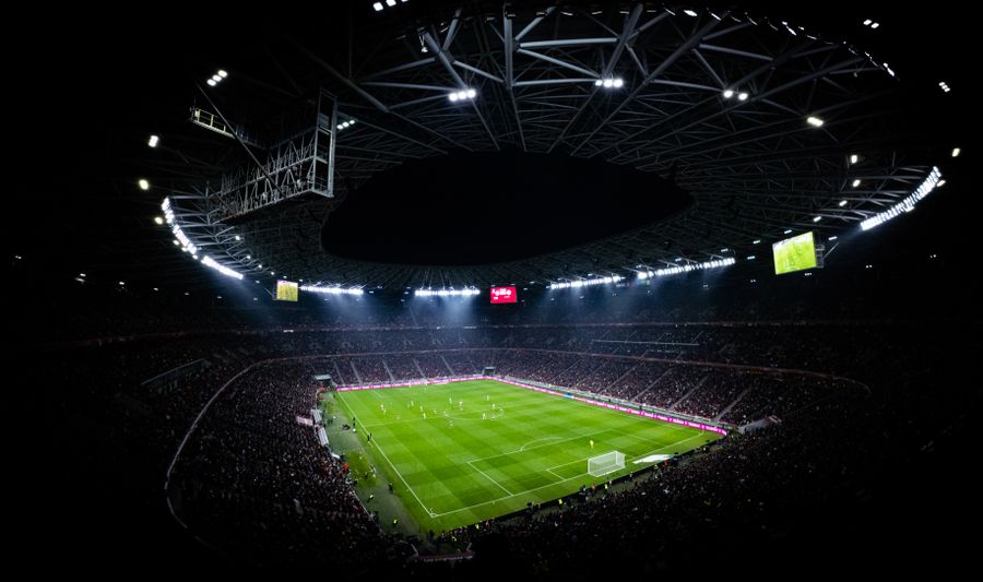 Stadion sepak bola menyala di malam hari penuh penonton