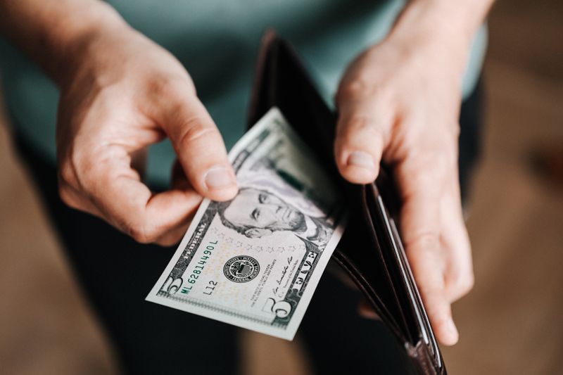 Tangan memasukkan uang ke dompet